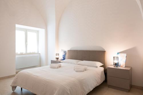 a white bedroom with a large bed with two towels on it at La casina - YourPlace Abruzzo in Fossacesia