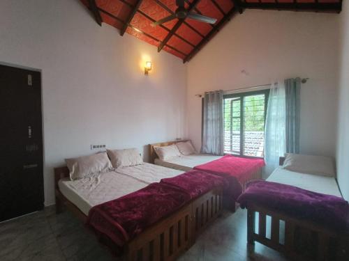 a bedroom with two beds and a window at Greenview Homestay in Sakleshpur