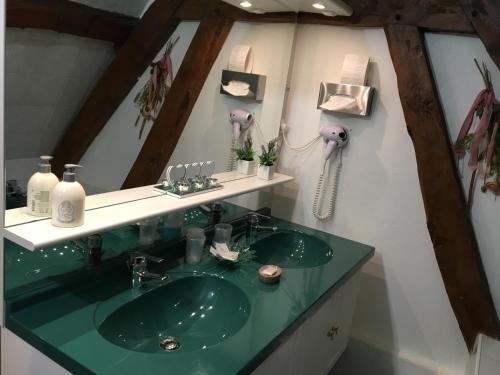 a bathroom with a green sink and a phone at Ferme Des Chartroux in Maresville