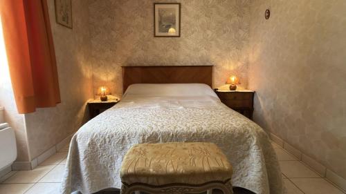a bedroom with a bed with two lights on the wall at Le gîte du porche in Saint-Georges-lès-Baillargeaux