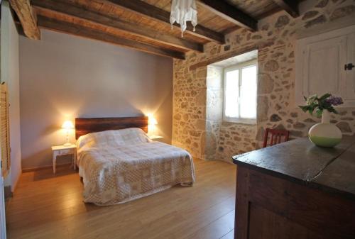 a bedroom with a bed in a room with wooden floors at Lascaux in Saint-Mathieu