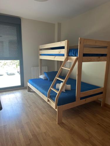 a bedroom with a bunk bed with blue sheets at Refugio PIRENAICO in Sabiñánigo