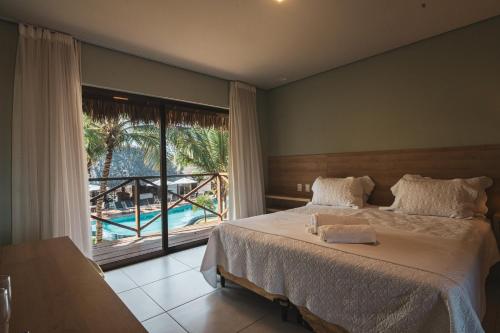 a bedroom with a bed with a view of a pool at Villas BobZ in Barrinha
