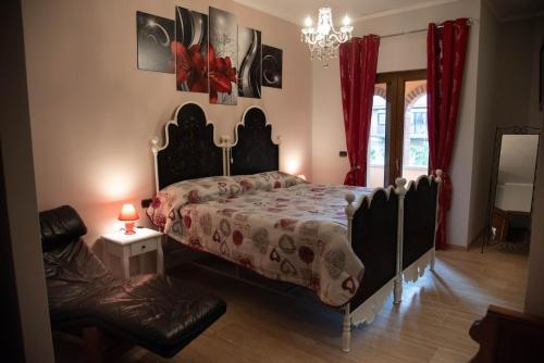 a bedroom with a bed and a chair and a chandelier at B&b Villa Sofia in Fara Novarese
