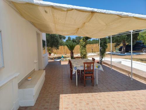 a patio with a table and chairs under a tent at DolceApulia Country House in Conversano