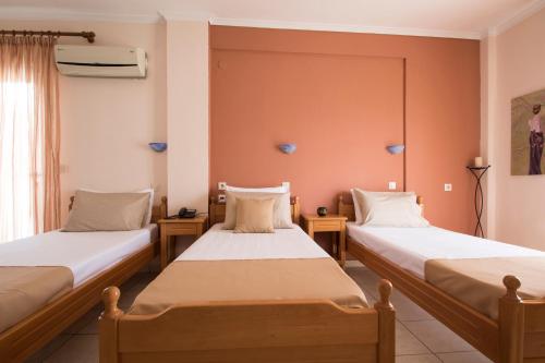 two beds in a room with orange walls at Iris by Dias in Olympic Beach