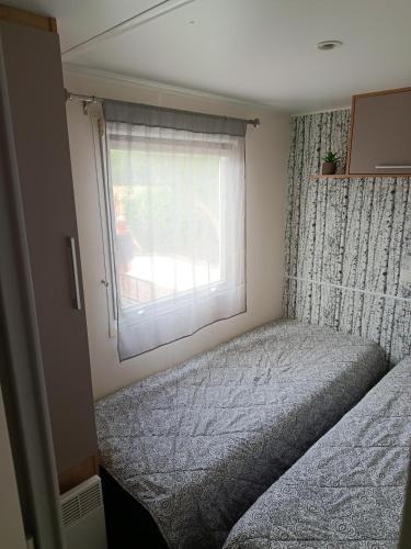 a small bedroom with a bed and a window at Le Deauville in Le Grau-dʼAgde