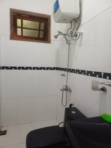 a bathroom with a toilet and a window at Sunlee Aviana in Bandarawela