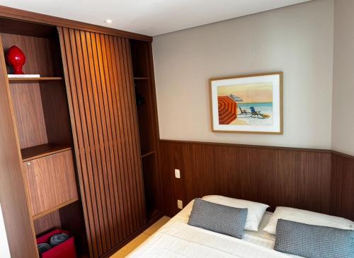 a bedroom with a bed and a picture on the wall at Apto em Santos - UNIQUE Residence in Santos