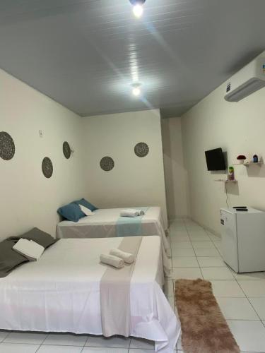 a room with two beds and a tv in it at Pousada Dona Dulce in Barreirinhas