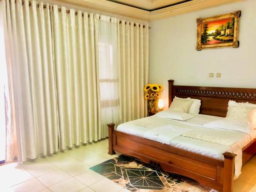 a bedroom with a bed and a large window at Gravity Villa Musanze in Ruhengeri