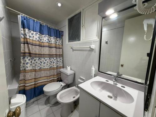 a bathroom with a sink and a toilet and a mirror at Intimo Hotel Miraflores in Santiago