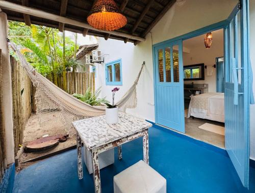 a room with a hammock and a bedroom at Pousada Caraíva in Caraíva