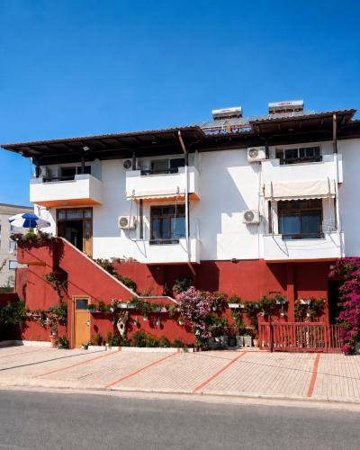 a red and white building with flowers in front of it at Villa Hodo in Vlorë