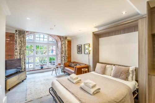 a bedroom with a large bed and a large window at York Cocoa Suites - city centre apartments in York