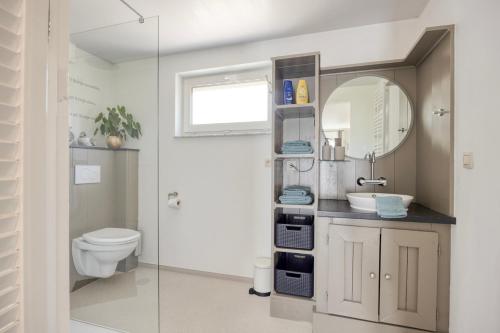 a bathroom with a toilet and a sink and a mirror at B&B Cosiness in Balen
