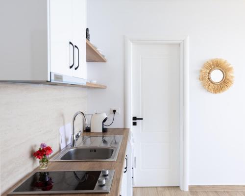 a white kitchen with a sink and a door at Oceanfront Oasis in Borsh