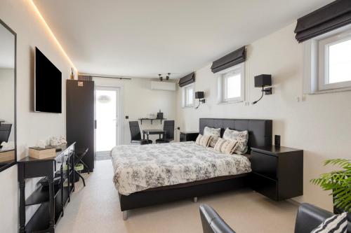 a bedroom with a bed and a desk and a television at B&B Cosiness in Balen