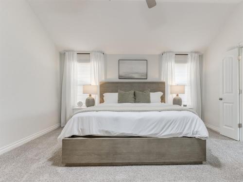 a white bedroom with a large bed with white sheets at Spacious Modern Comfort Fabulous 15th! in Moore