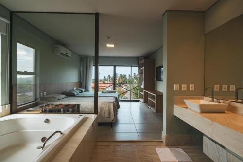 a bathroom with a bed and a bath tub and a sink at Villas BobZ in Barrinha