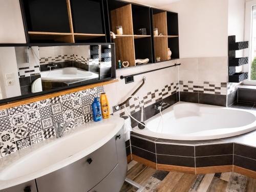 a bathroom with a large tub and a sink at ti ar maez in Mauron