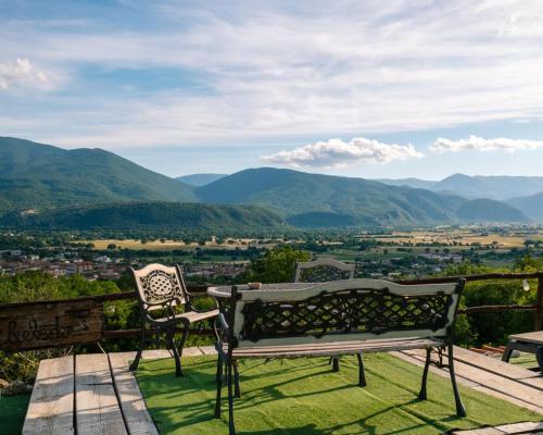 a bench on a deck with a view of mountains at B&B LE GRETTE in Gioia dei Marsi
