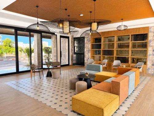 a living room with couches and tables and windows at Le Corail Apart'Hotel & Splash Park in Hammamet