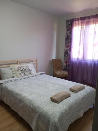 a bedroom with a bed and a chair and a window at Saulespuķe-Kuldīgā in Kuldīga