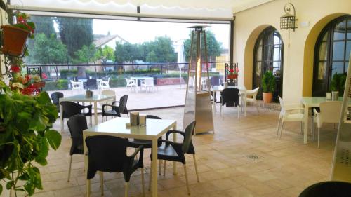 a restaurant with tables and chairs and a patio at Hospedería Convento de Santa Clara in Palma del Río