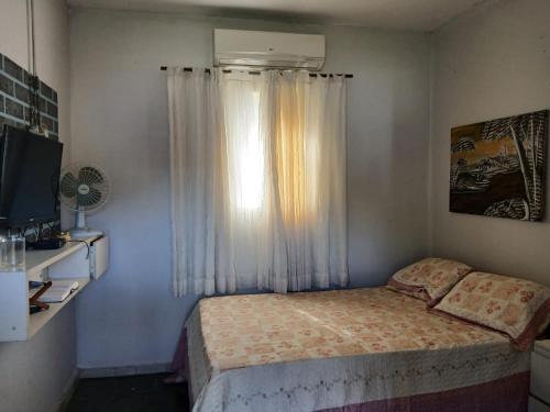 a small bedroom with a bed and a window at sitio Ibiúna in Ibiúna