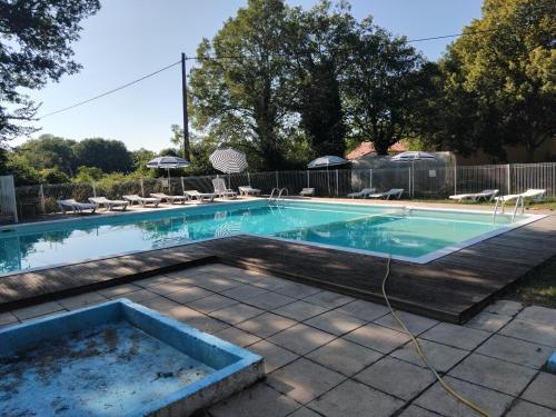 a swimming pool with a hose in a yard at N1 Emplacement tente van camping-car in Saint-Aubin-de-Nabirat