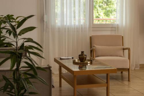 a living room with a chair and a coffee table at Diame Suite - Tzivelekidou in Chrysoupolis