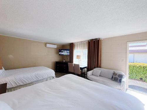 a hotel room with two beds and a chair at Royal Inn and Suites in Hemet