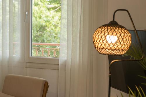 a lamp in a room next to a window at Diame Suite - Tzivelekidou in Chrysoupolis