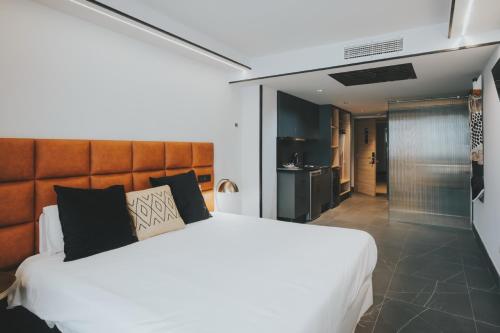 a bedroom with a large bed and a kitchen at Poem Suites by Airnest in Las Palmas de Gran Canaria
