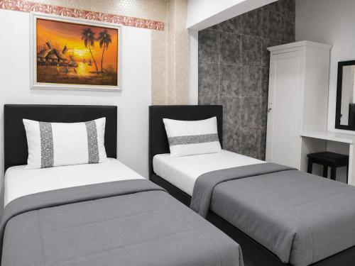 two beds in a small room withermottermottermottermott at NamRoom at Jatiwaringin in Jakarta