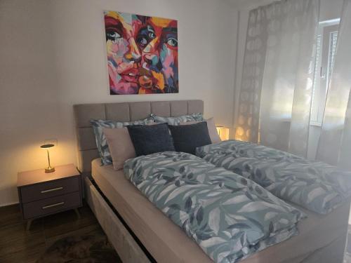 a bed in a bedroom with a painting on the wall at Moreto in Slano