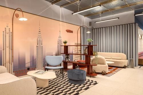 a lobby with furniture and a mural of a city at B&B HOTEL Wrocław Old Town in Wrocław