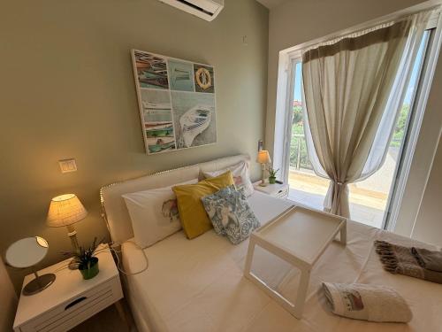a living room with a white couch and a window at Villa Evita , penthouse, 53m2 ,Athytos , astonishing sea view in Afitos