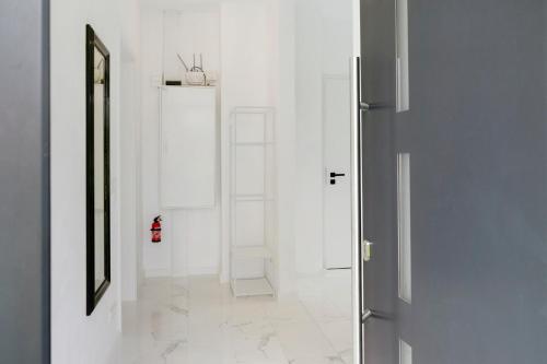 a hallway with white walls and a door and a shelf at Auszeit in der Heide mit Terrasse in Bienenbüttel