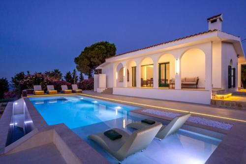 a villa with a swimming pool at night at Xenia Sea view Villa in Argassi