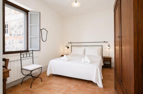 a bedroom with a white bed and a window at Casale del Conte in Pienza