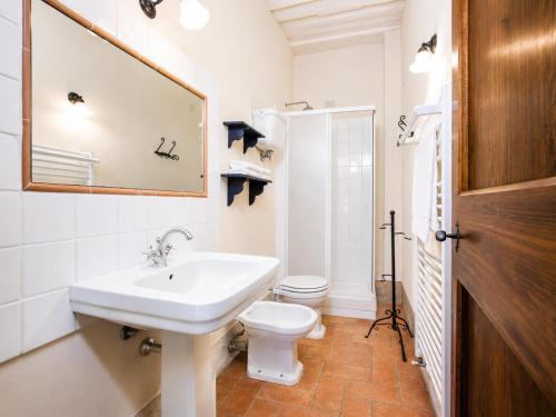 a bathroom with a sink and a toilet and a mirror at Casale del Conte in Pienza