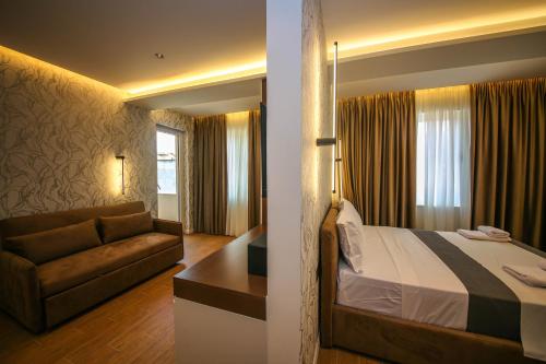 a hotel room with a bed and a couch at Comfort Boutique Hotel in Tirana