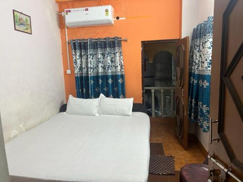 a small bedroom with a bed in a room at Priyadarshi Hotel in New Digha