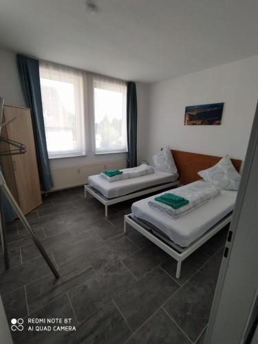 two beds in a room with two windows at Holidayapartment Bella Napoli in Liblar