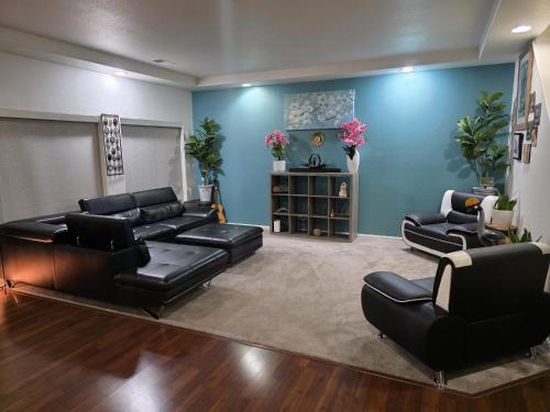 a living room with black leather furniture and blue walls at Jule Sleep in Denver