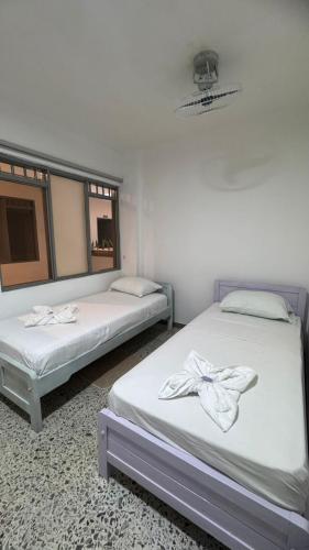 two beds sitting next to each other in a room at karolina Real Hotel Experience in Apartadó