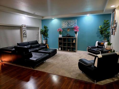 a living room with black leather furniture and blue walls at Jule Sleep in Denver