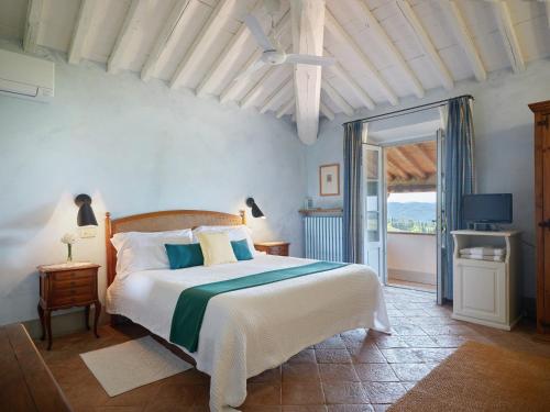 a bedroom with a large bed and a balcony at La Locanda Volpaia in Radda in Chianti